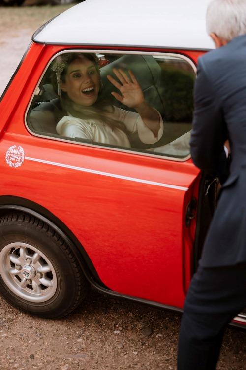 la novia saliendo de un mini morris rojo