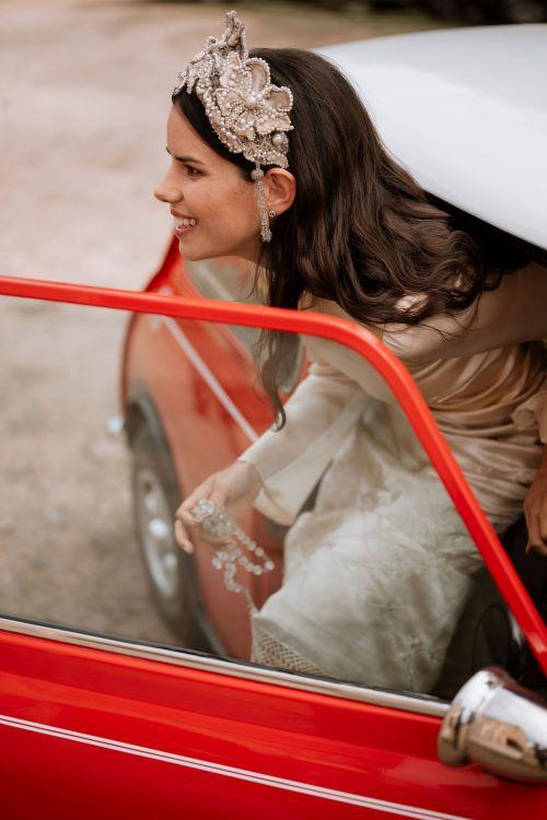 la novia saliendo de un coche rojo